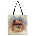 A natural colored canvas tote bag with a picture of Pomeranian on a blue, pink, and purple watercolor background.