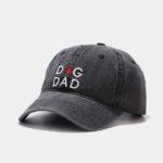 A vintage distressed dark gray baseball cap with "dog dad" written in white letters. The 'O' in "Dog" is a red pawprint.